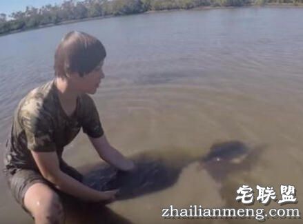 小孩海边玩耍时在水中发现鲨鱼，没想到竟然赤手空拳把它抓起！